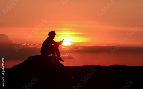 Freelancer siting on ocean beach with phone in hands at sunset. Happy man in love  freedom concept