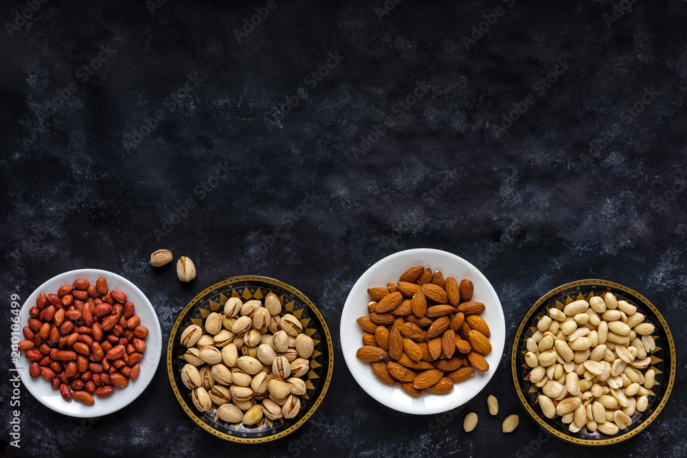 Border with bowls of assorted fresh nuts Border with bowls of assorted fresh nuts