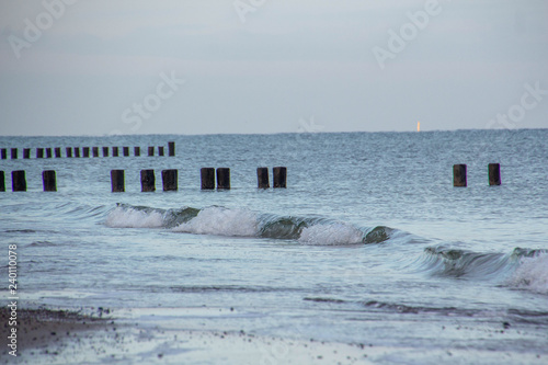 waves on water with wooden posts