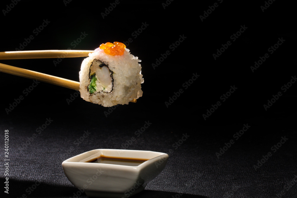 Sushi Roll Japanese Food One Piece Of Sushi Roll With Chopsticks Isolated On Black Background Stock Photo Adobe Stock
