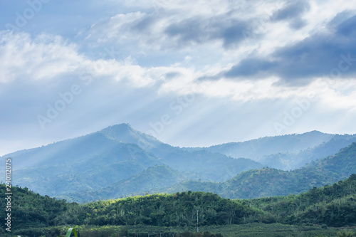 The sun shining through the clouds to the trees on the mountain at Suan phueng of Ratchaburi in Thailand.