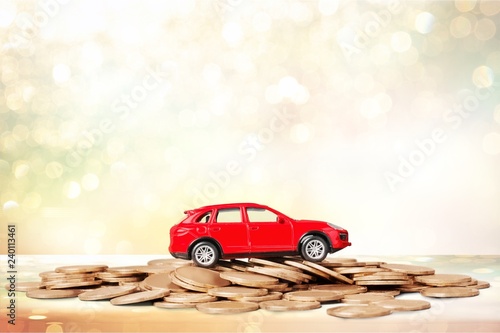 Golden coins and toy car on background