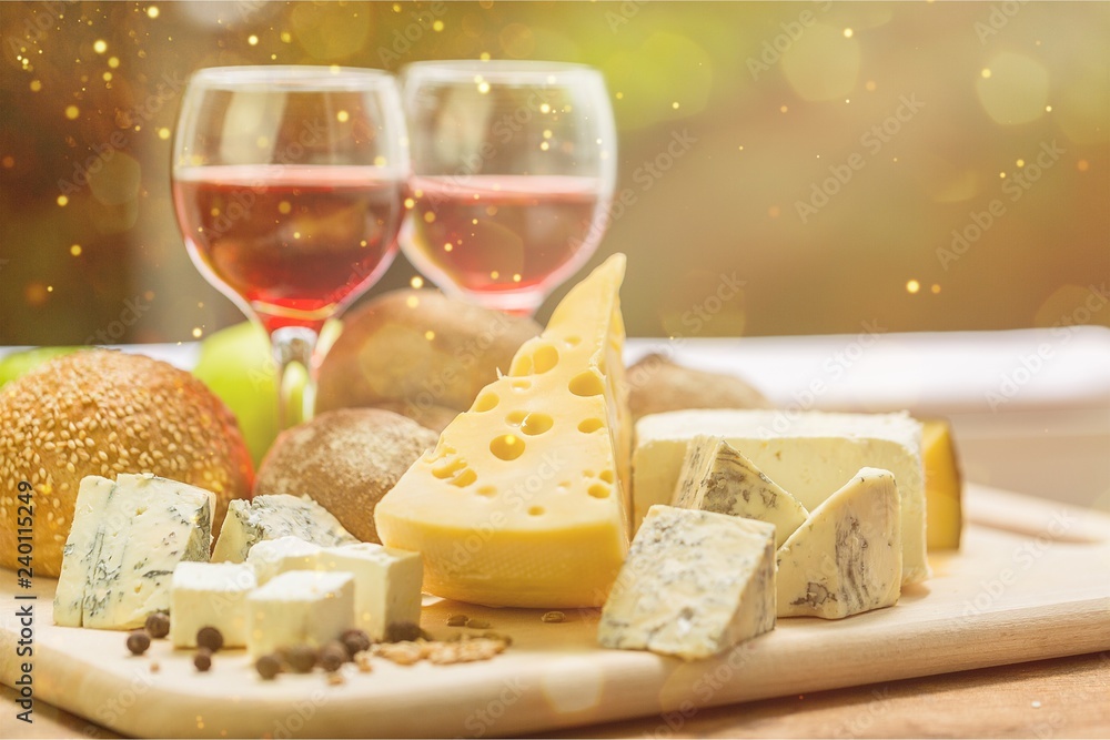 Assortment of cheese on board and two glasses of wine Assortment of cheese on board and two glasses of wine