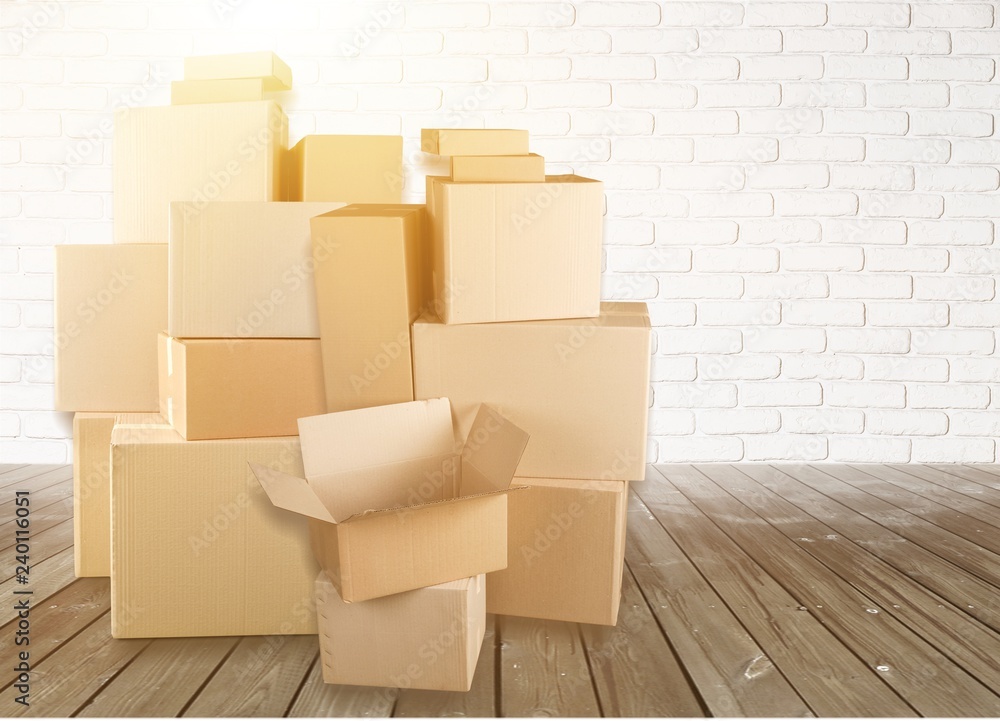 Different cardboard boxes in room on wooden floor Different cardboard boxes in room on wooden floor