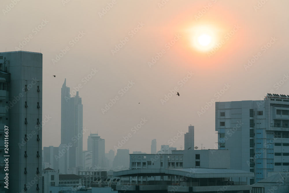 Air pollution effect made low visibility cityscape with haze and fog from dust in the air during sunset in Bangkok, Thailand.