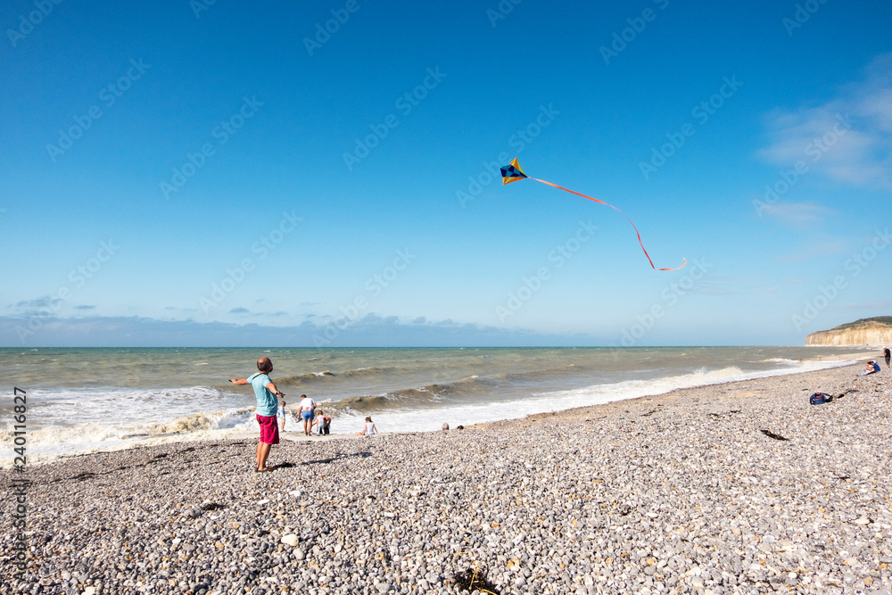 A man controls a kite on the beach in Quiberville, France