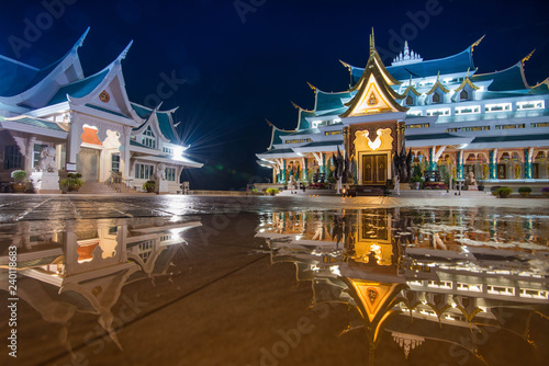 Fototapeta Naklejka Na Ścianę i Meble -  Thai temple beautiful at night twilight blue sky and light reflect on ground - Wat Pa Phu Kon Udon Thani Thailand