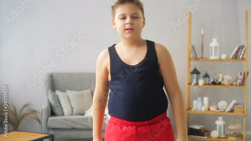 Fat boy doing exercises in the hall