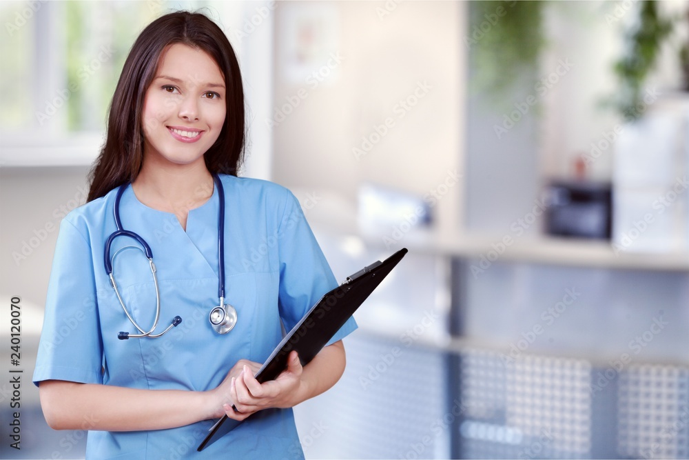 Attractive young female doctor with blurred hospital interior on Attractive young female doctor with blurred hospital interior on