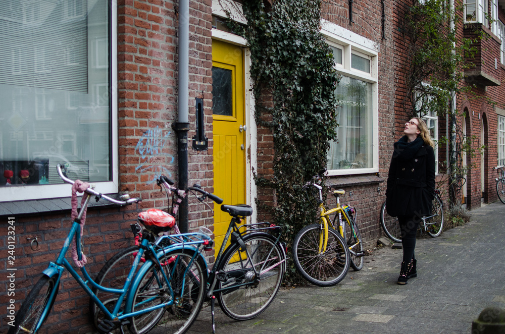 photograph of a girl walking admiring the houses of a street in Netherlands