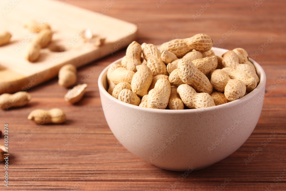 raw peanuts in shell on a wooden background. raw peanuts in shell on a wooden background.