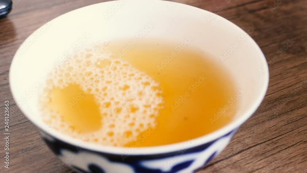 Close up of hot green tea pouring into asian uzbek national dish bowl. Tea drinking in Uzbekistan Close up of hot green tea pouring into asian uzbek national dish bowl. Tea drinking in Uzbekistan