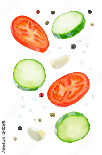 Fototapeta Naklejka Na Ścianę i Meble -  Flying Cucumber slices with tomato slices