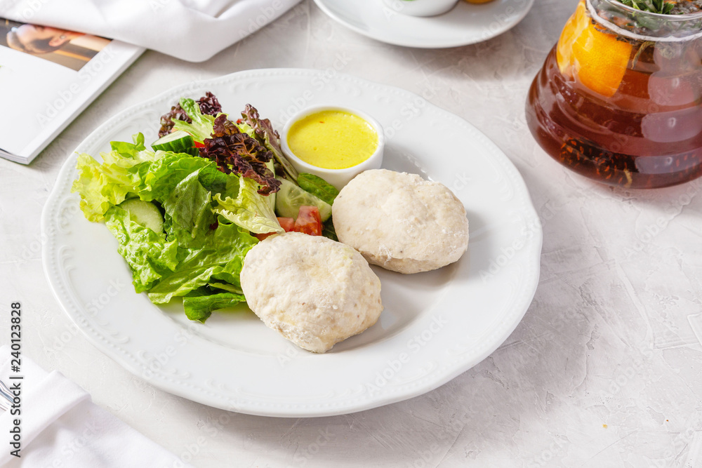 Steamed patties with fresh vegetables in a plate on the table Steamed patties with fresh vegetables in a plate on the table