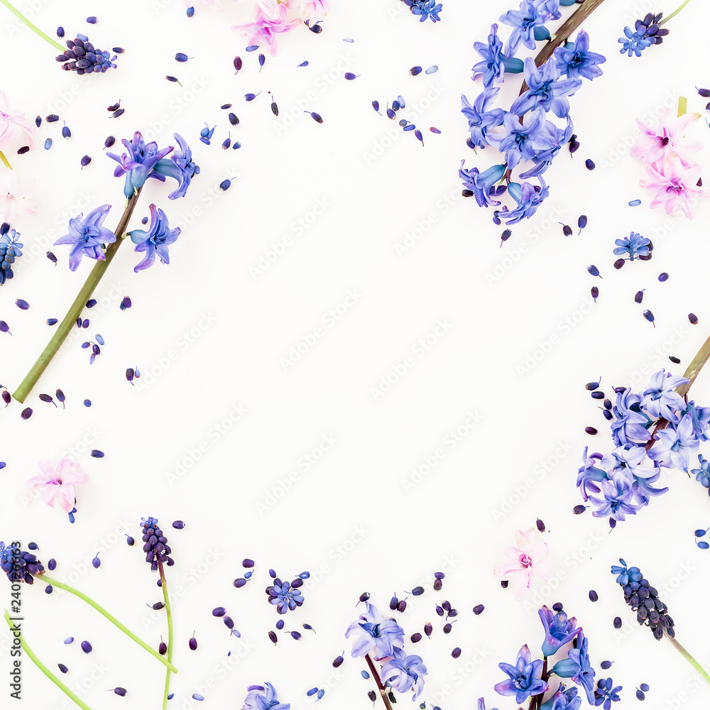Floral frame with blue spring flowers and pink hyacinth flower on white background. Flat lay, top view. Valentines day