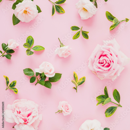 Pattern composition with roses flowers and leaves on pastel pink background. Flat lay  top view.