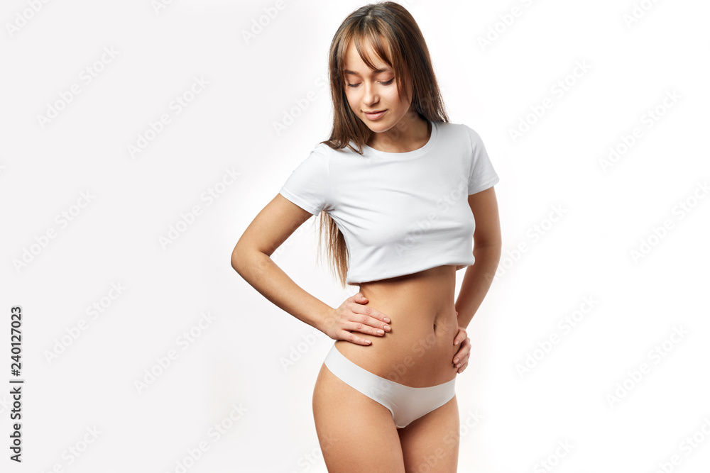 Fotografia do Stock: Beautiful young woman dressed in white top and panties  shows her slim body and flat tummy. Girl With Perfect Body Shape, Flat  Belly In Underwear. Health, Hygiene Concepts.