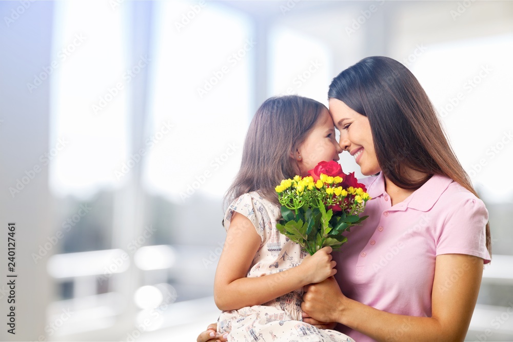 Portrait of happy mother and daughter holding flowers Portrait of happy mother and daughter holding flowers