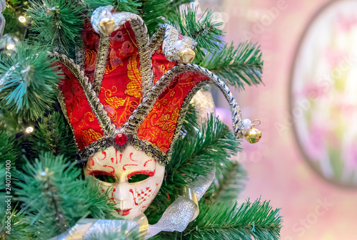 Colorful carnival mask on the background of the Christmas tree.