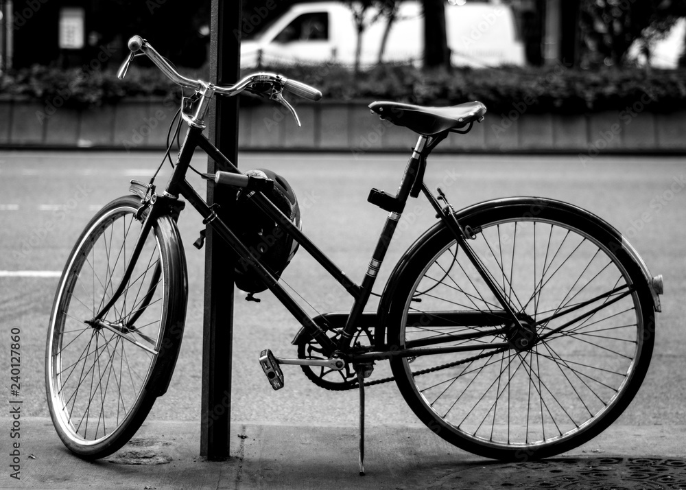 vintage bicycle chained to post in the city