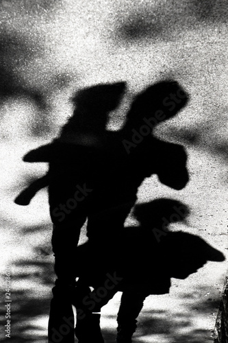 Black and white silhouette and shadow of a family on the street