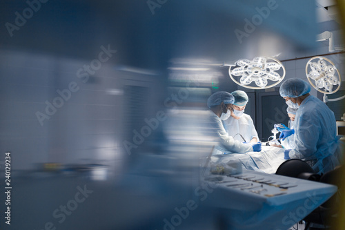 Operation room surgery in hospital, blurred figures. Professional treatment and professional conduct concept. photo