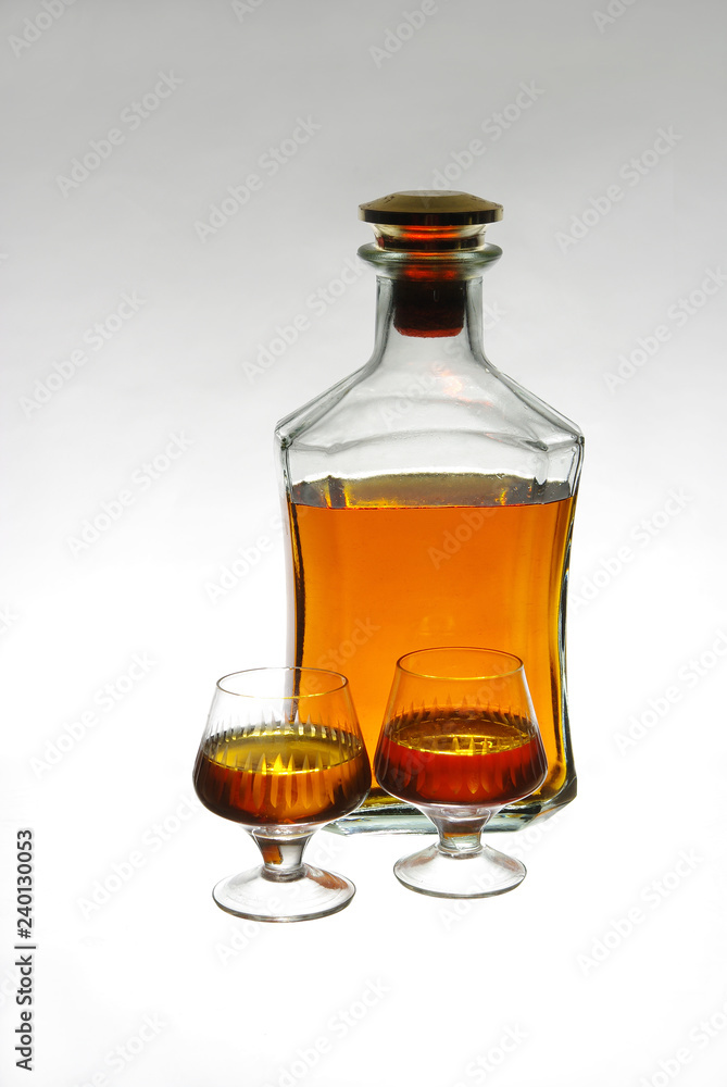 Strong drinks. Glass of cognac and bottles Strong drinks. Glass of cognac and bottles