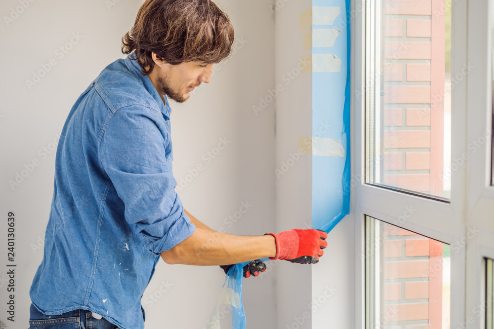 Man in a blue shirt does window installation Man in a blue shirt does window installation