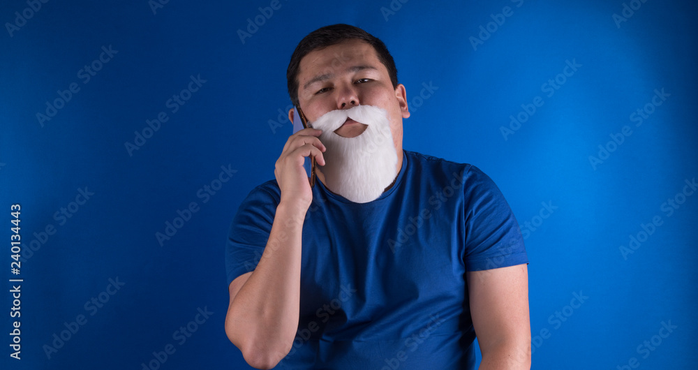studio portrait of a man with a white beard blue background