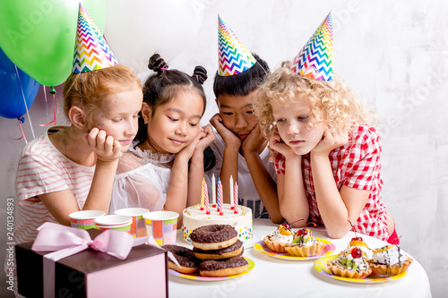 sweet kids with cake and other sweets. closeup photo.friendly diverse children in decorated room