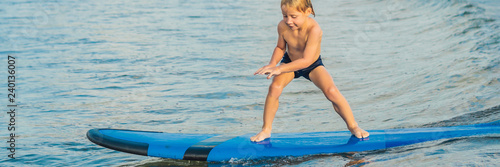Little boy surfing on tropical beach. Child on surf board on ocean wave. Active water sports for kids. Kid swimming with surf. Surfing lesson for kids BANNER, LONG FORMAT