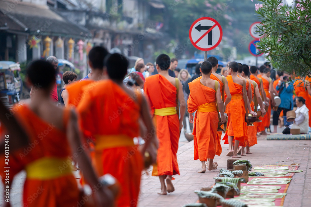 Buddhist novice monks with buddhist alms giving ceremony at Luang Prabang. - obrazy, fototapety, plakaty 