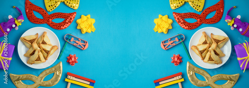 Jewish holiday Purim background with carnival mask, noisemaker and hamantaschen cookies