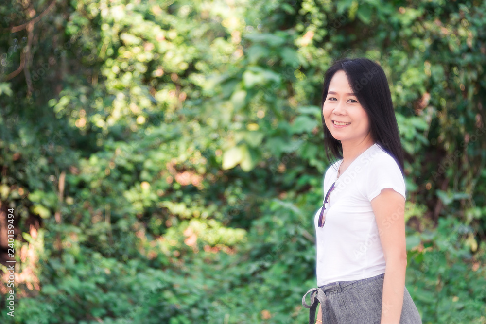 Beautiful Asian Woman Relaxing Outdoors in Green Nature Background. Beautiful Asian Woman Relaxing Outdoors in Green Nature Background.