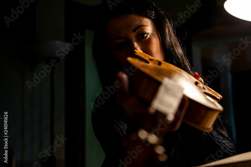 Obraz na plátně young woman apprentice violinmaker checking her violin