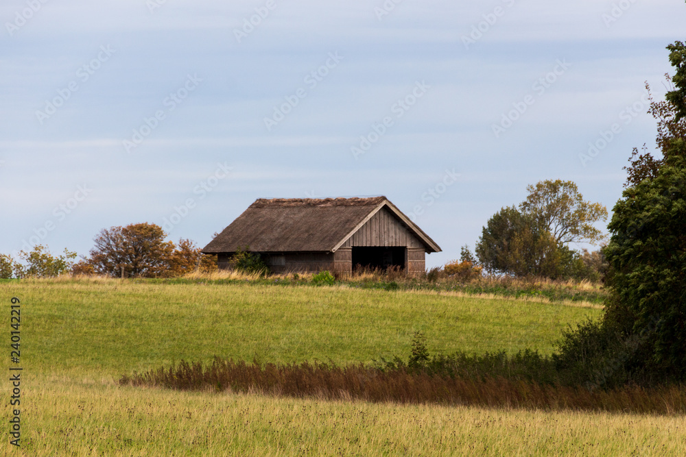 Scheune aus Holz auf einer herbstlichen Wiese auf der Insel Nyord in Dänemark Scheune aus Holz auf einer herbstlichen Wiese auf der Insel Nyord in Dänemark