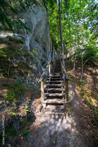 tourist trail with wooden pathwalk and stairs near sandstone cliffs