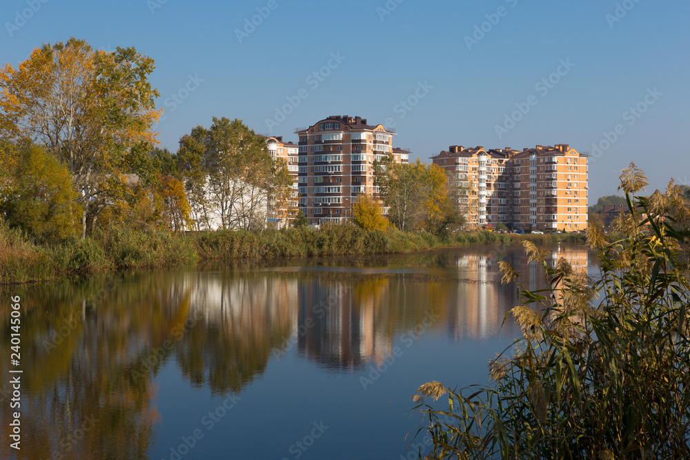 Modern residential complex on the shores of a picturesque lake on a sunny day. Modern residential complex on the shores of a picturesque lake on a sunny day.