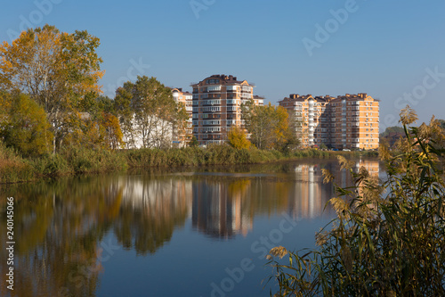 Modern residential complex on the shores of a picturesque lake on a sunny day.