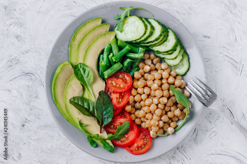 Healthy vegetarian food chickpeas, avocado, tomatoes, cucumbers, green beans top view