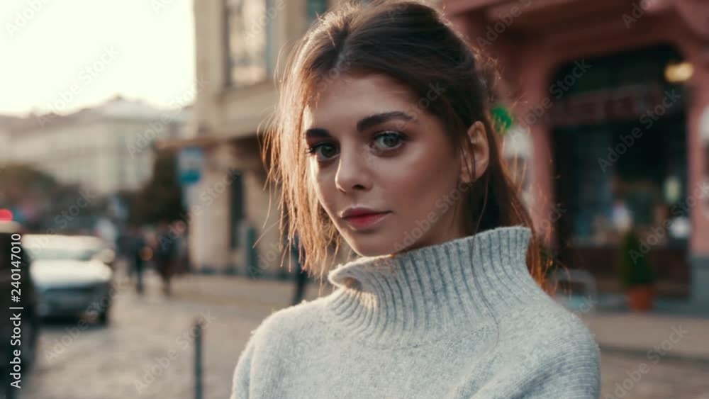 Charming young woman with big eyes beautiful makeup look at camera in the city center portrait model attractive hair sexy posing pretty street stylish close up slow motion Charming young woman with big eyes beautiful makeup look at camera in the city center portrait model attractive hair sexy posing pretty street stylish close up slow motion
