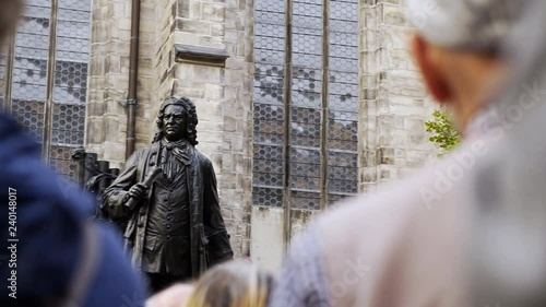 Back view crop people near sculpture of Johann Sebastian Bach on square in Leipzig 