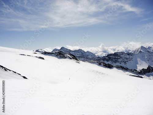 winter moutnain landscape in the Austrian Alps with many backcountry skiers crossing a large glacier and a great background view of the Hohen Tauern mountains in East Tyrol © makasana photo