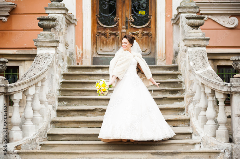 Fototapeta premium Beautiful european bride walking near old castle and have fun