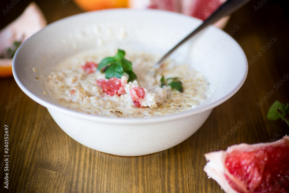 sweet oatmeal with slices of red grapefruit in a ceramic bowl sweet oatmeal with slices of red grapefruit in a ceramic bowl
