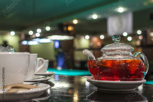 Glass teapot. Fruit and citrus tea. Hot morning drink. A warming drink with pieces of fruit. Glass teapot for tea. Beautiful tea service in the restaurant.