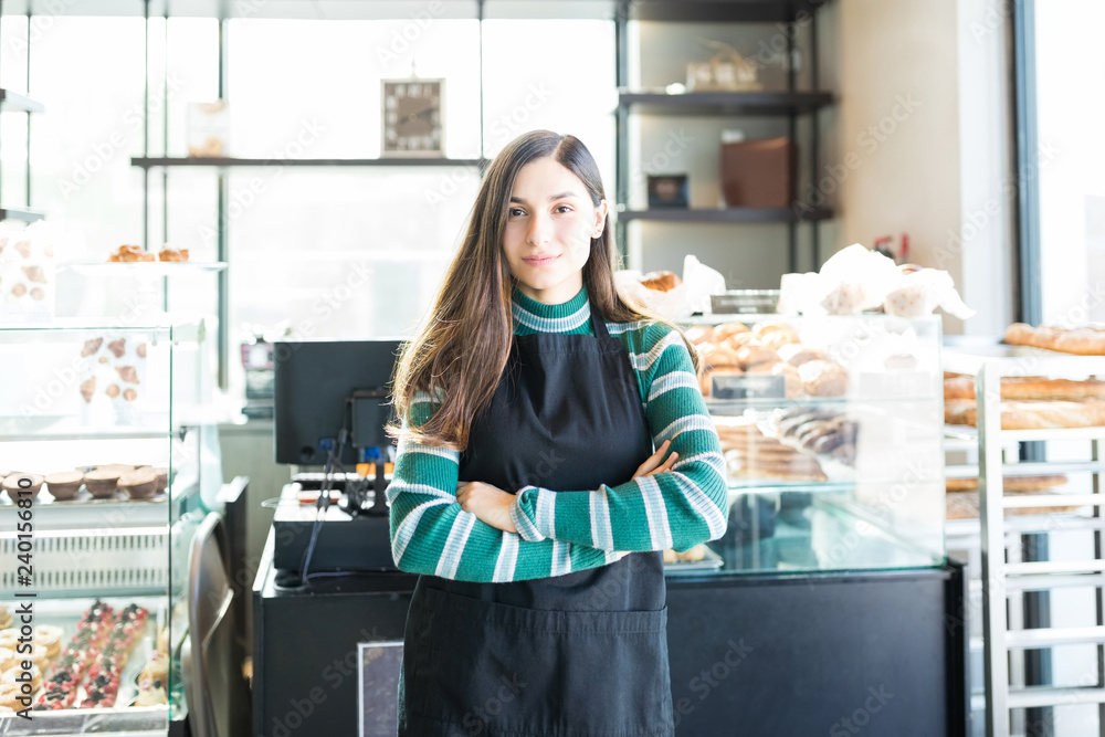 Confident Saleswoman Wearing Apron In Bakery Confident Saleswoman Wearing Apron In Bakery
