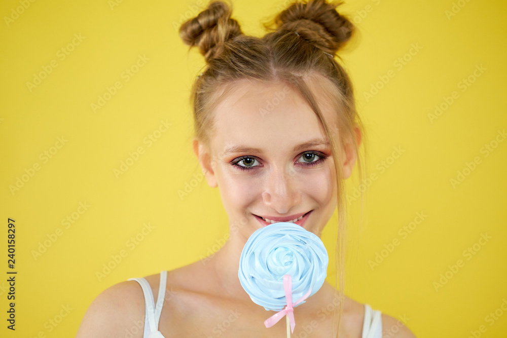 young girl with candy on a yellow bright background. beautiful make-up, young girl with candy on a yellow bright background. beautiful make-up,