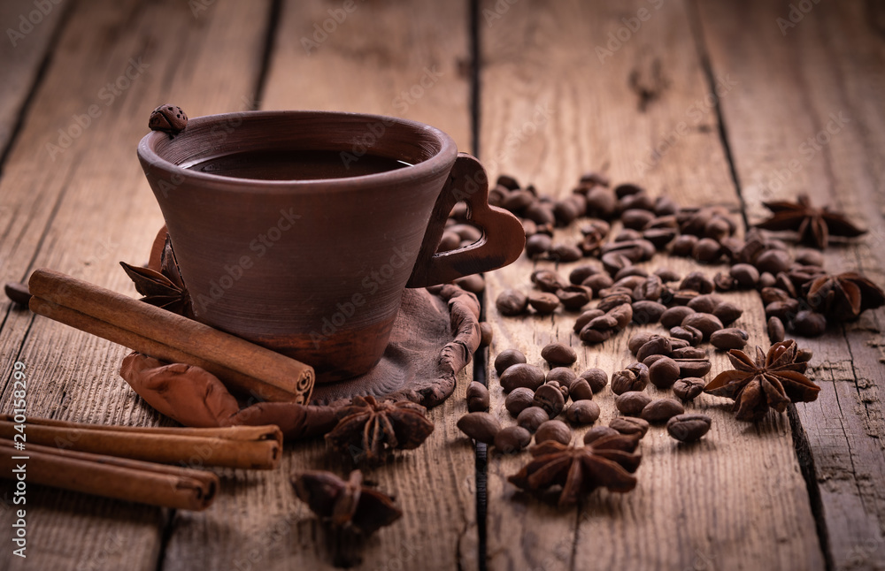 coffee beans in jute bag with coffee grinder and hot cup of coffee on wooden table