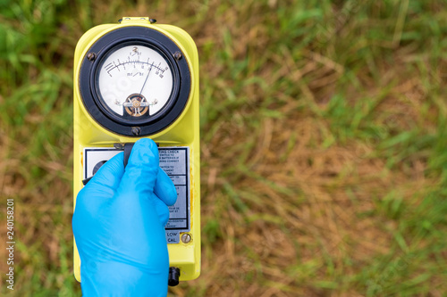 Canvas Print A blue gloved hand holds a radiation meter